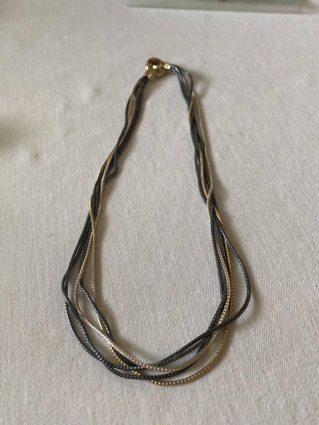 Multi-strand braided necklace with alternating gold and black-tone chains