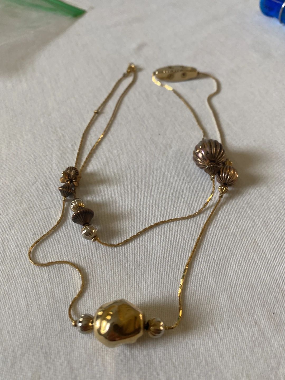 Gold-tone beaded necklace with varied hammered and fluted beads